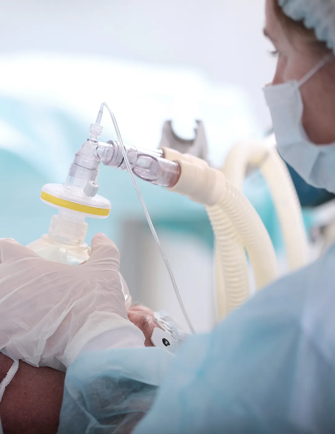 Medical assistant placing a mask on a patient.