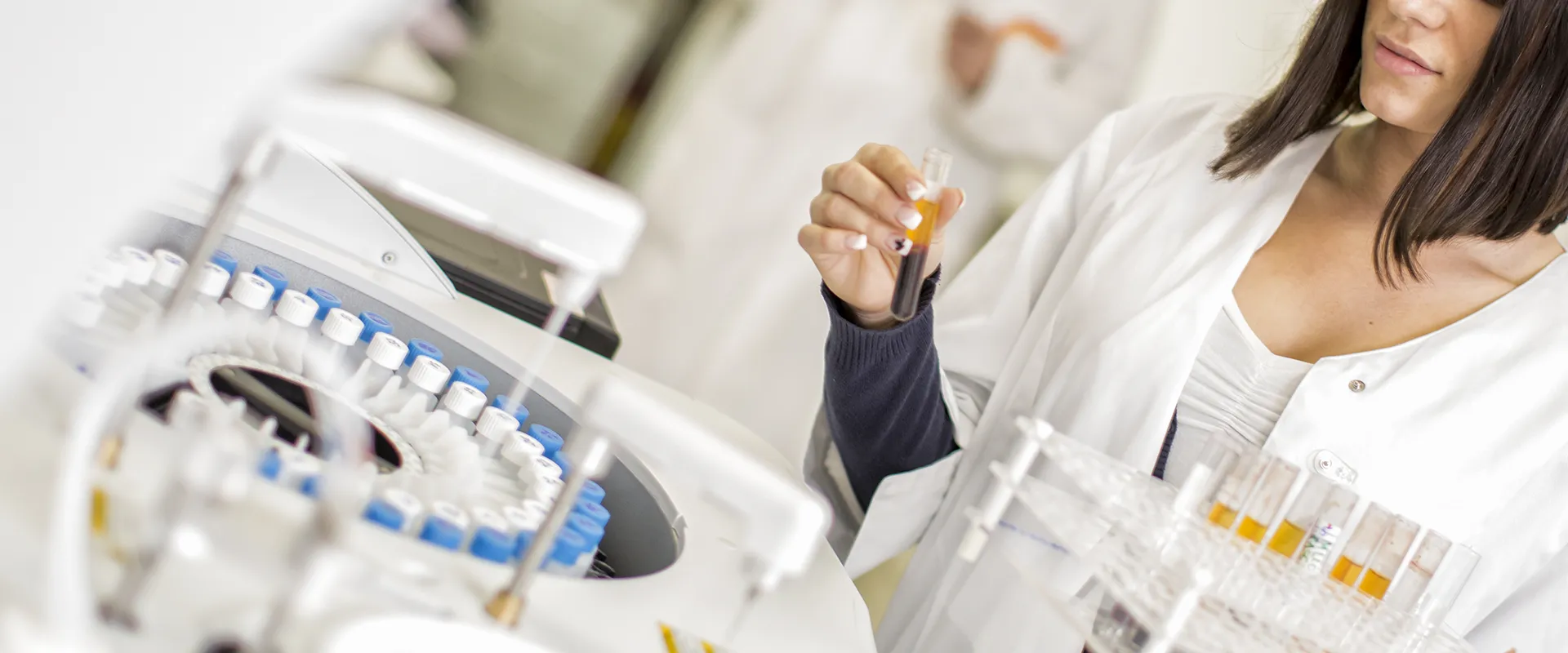 Woman holding a test tube containing a sample.
